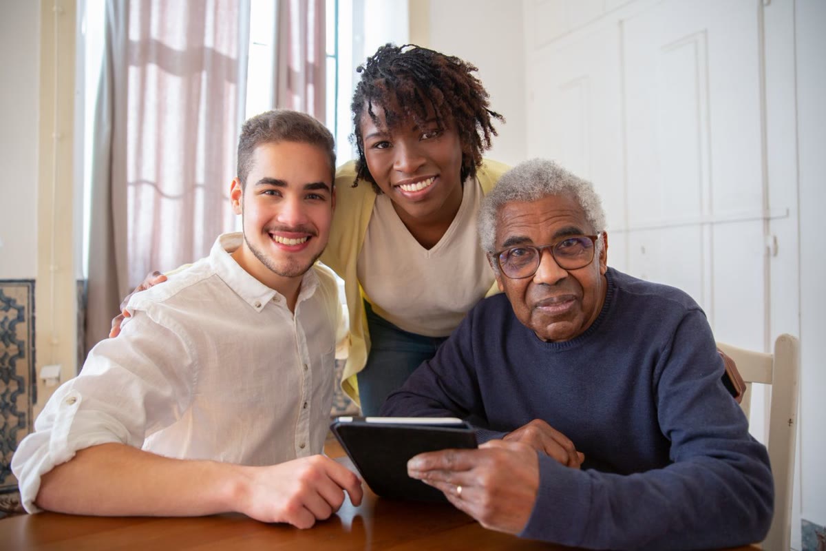 Multigenerational family gathered around a tablet in a sunlit home, planning a move together.