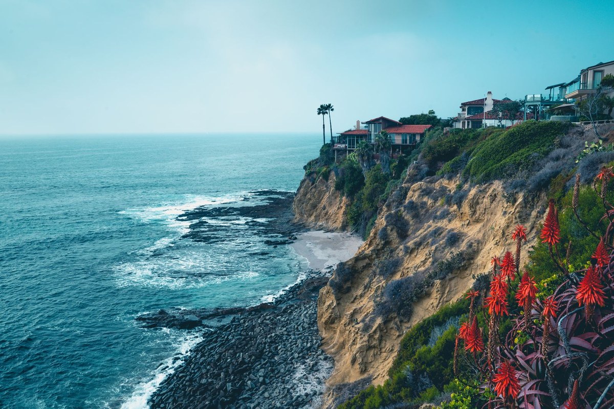 Coastal cliffs with luxury homes above the Pacific Ocean near Laguna Beach on a clear day.